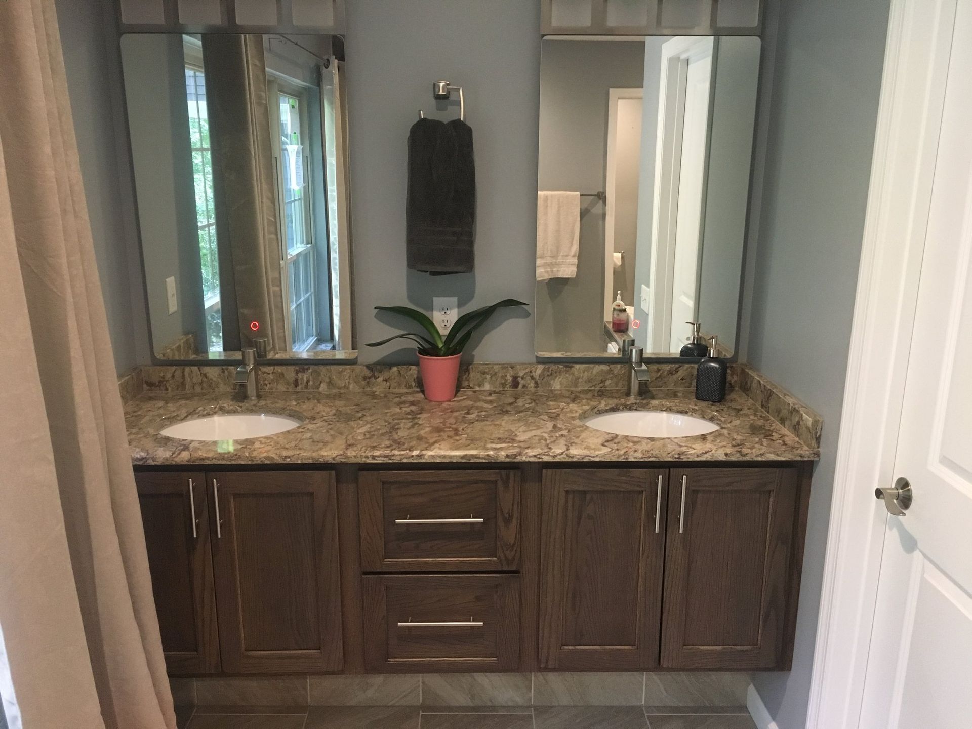 a bathroom with two sinks and two mirrors .