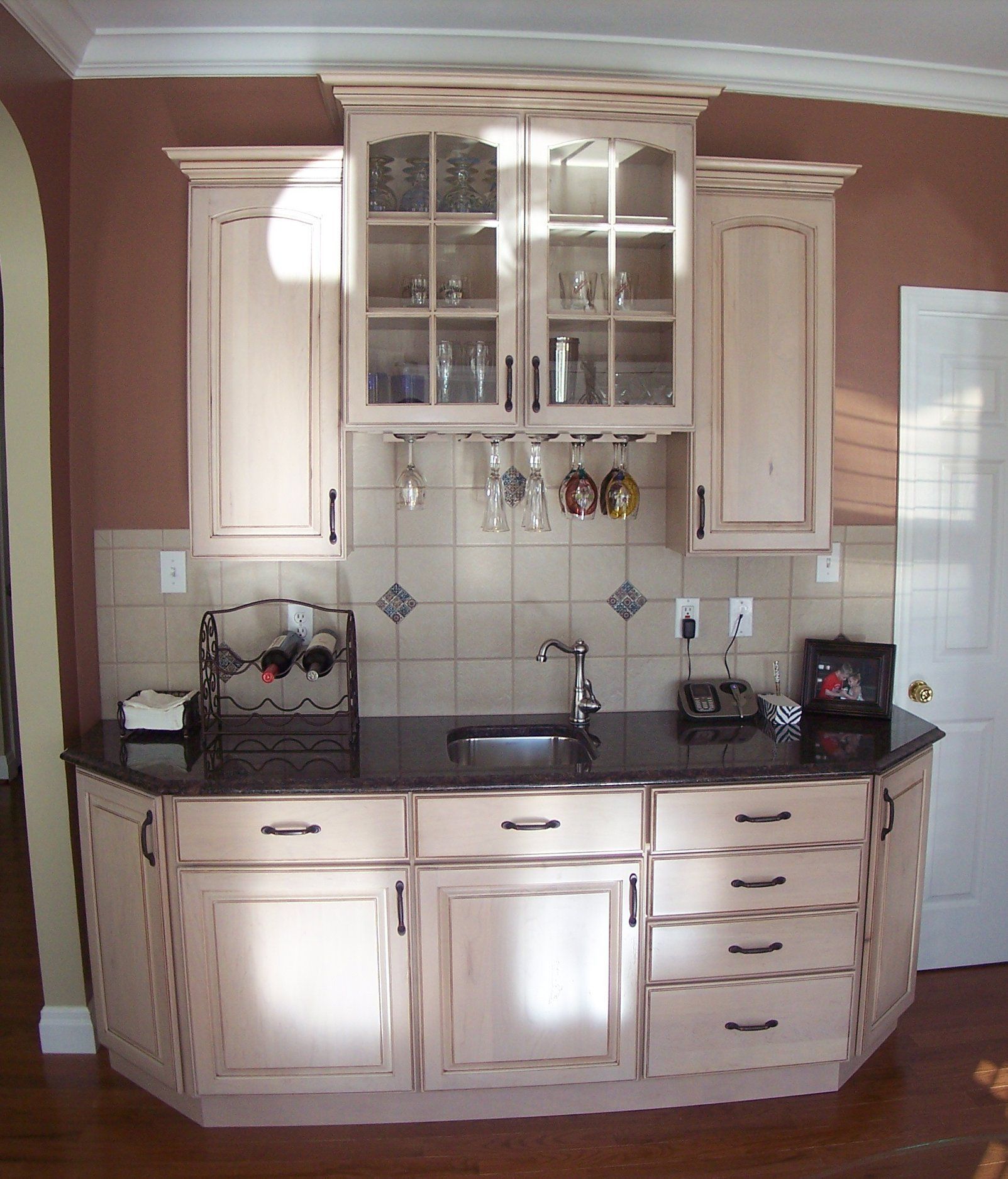 a kitchen with white cabinets and a black counter top