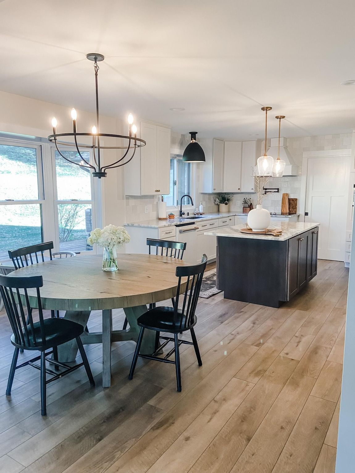 a kitchen with a table and chairs and a chandelier hanging from the ceiling .