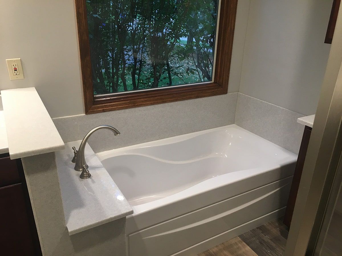 a bathtub in a bathroom next to a window .