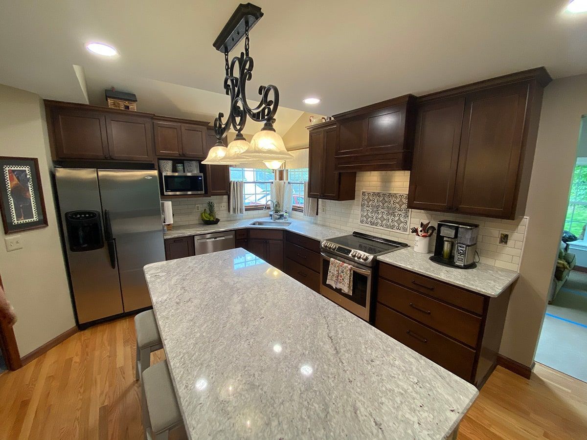 a kitchen with stainless steel appliances , granite counter tops , and wooden cabinets .