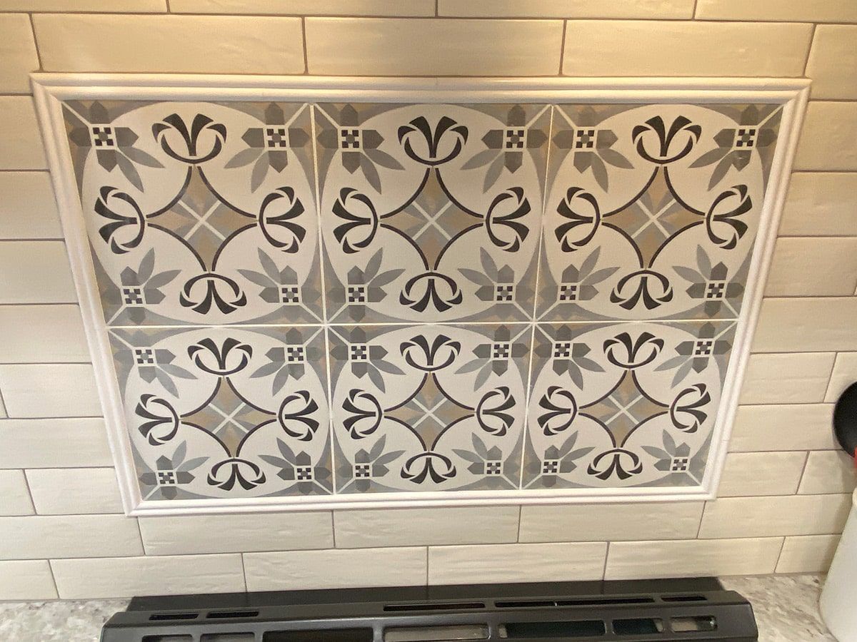 a white tile wall with a black and white pattern on it