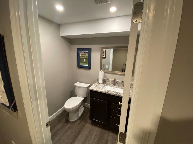 a bathroom with a toilet , sink and mirror .