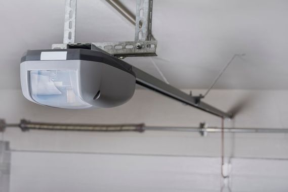 Garage door opener mounted on a ceiling track in a garage