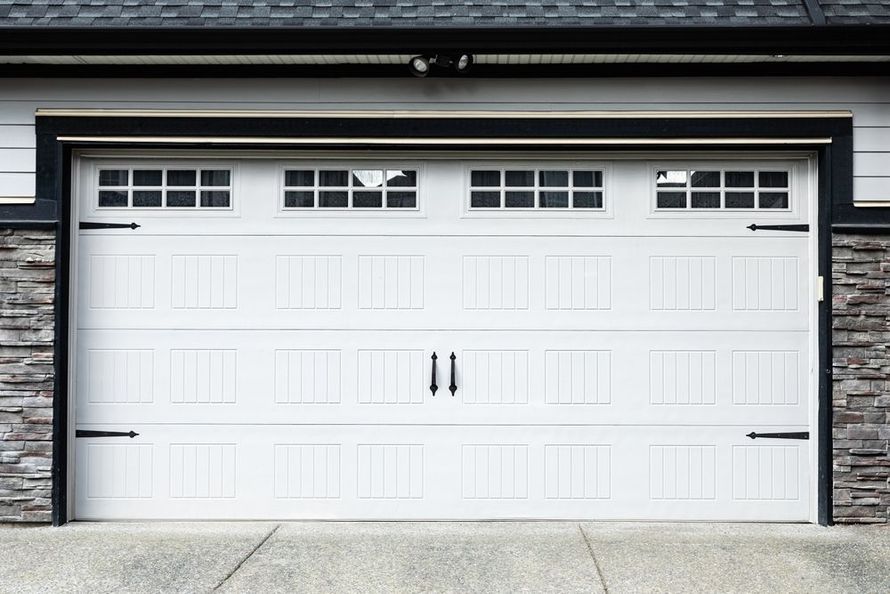 White double garage door with small windows on a house exterior