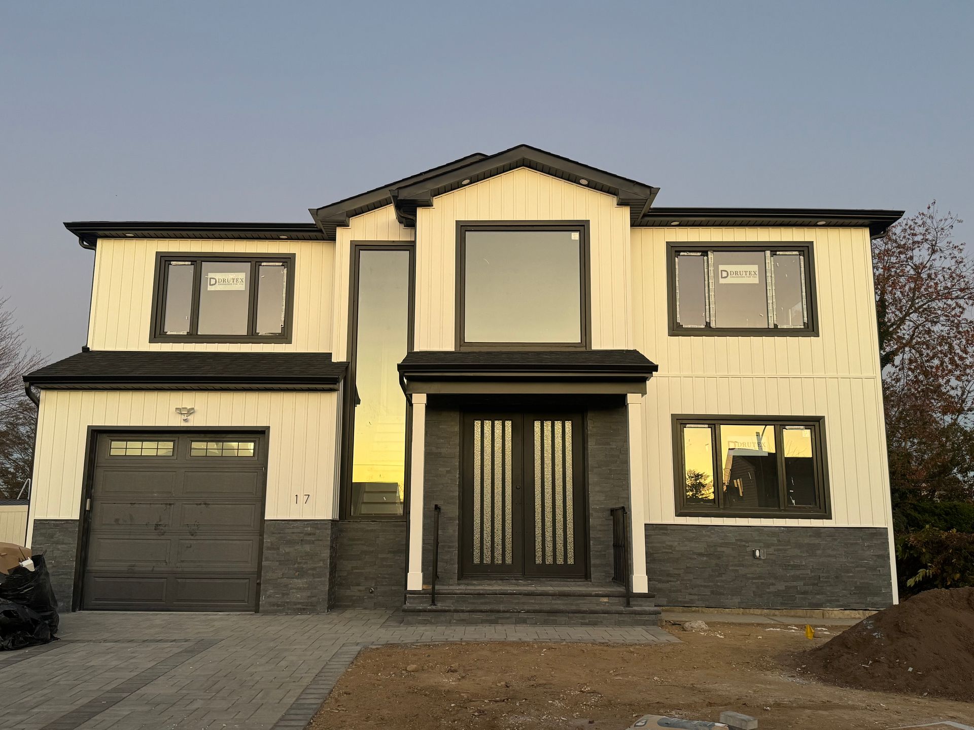 Modern two-story house with a garage, central entrance, and beige and gray exterior