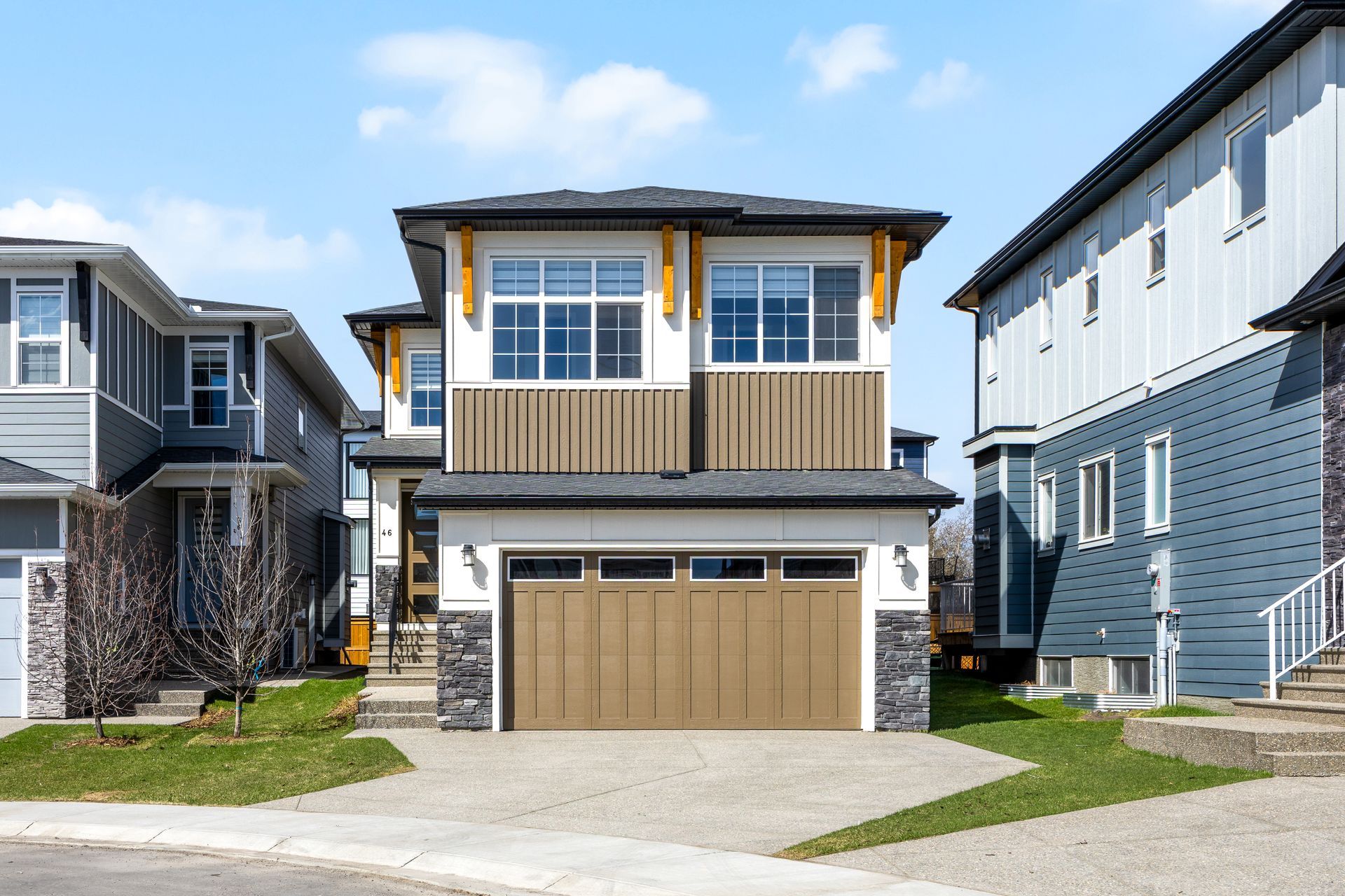 Modern two-story suburban house with beige garage, wood accents, and neighboring homes on both sides Modern two-story suburban house with beige garage, wood accents, and neighboring homes on both sides