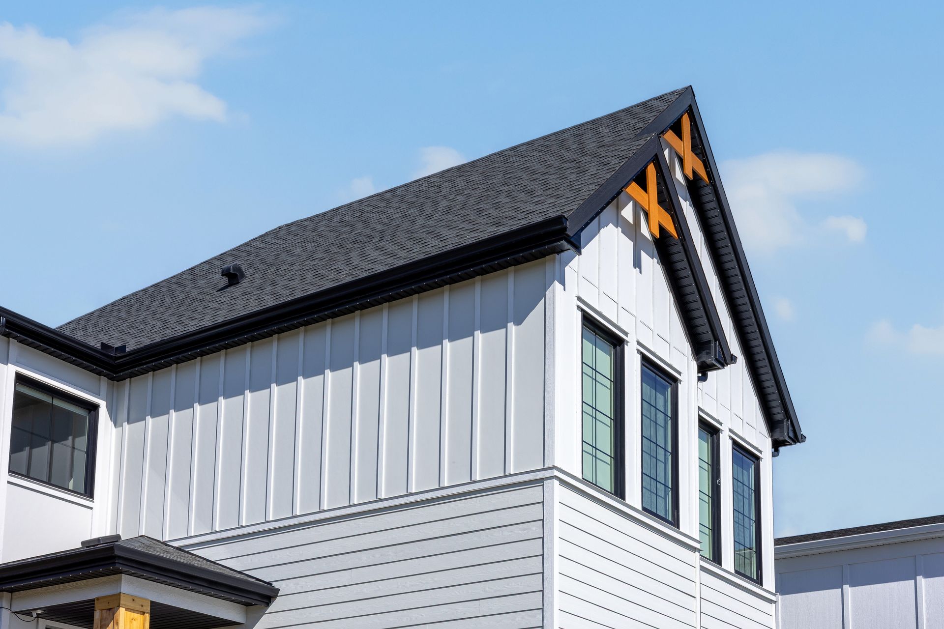 White house exterior with black roof and orange trim against a blue sky White house exterior with black roof and orange trim against a blue sky
