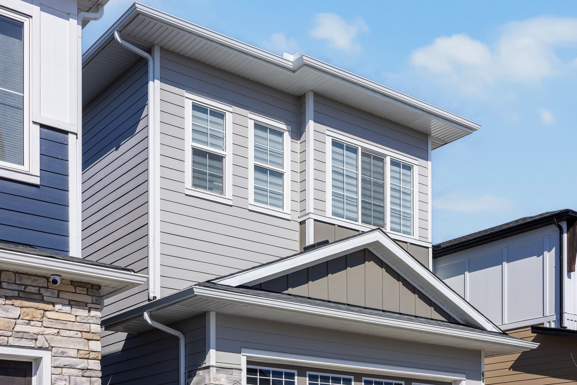 Exterior of a modern gray house with white-trimmed windows and a covered front porch Exterior of a modern gray house with white-trimmed windows and a covered front porch