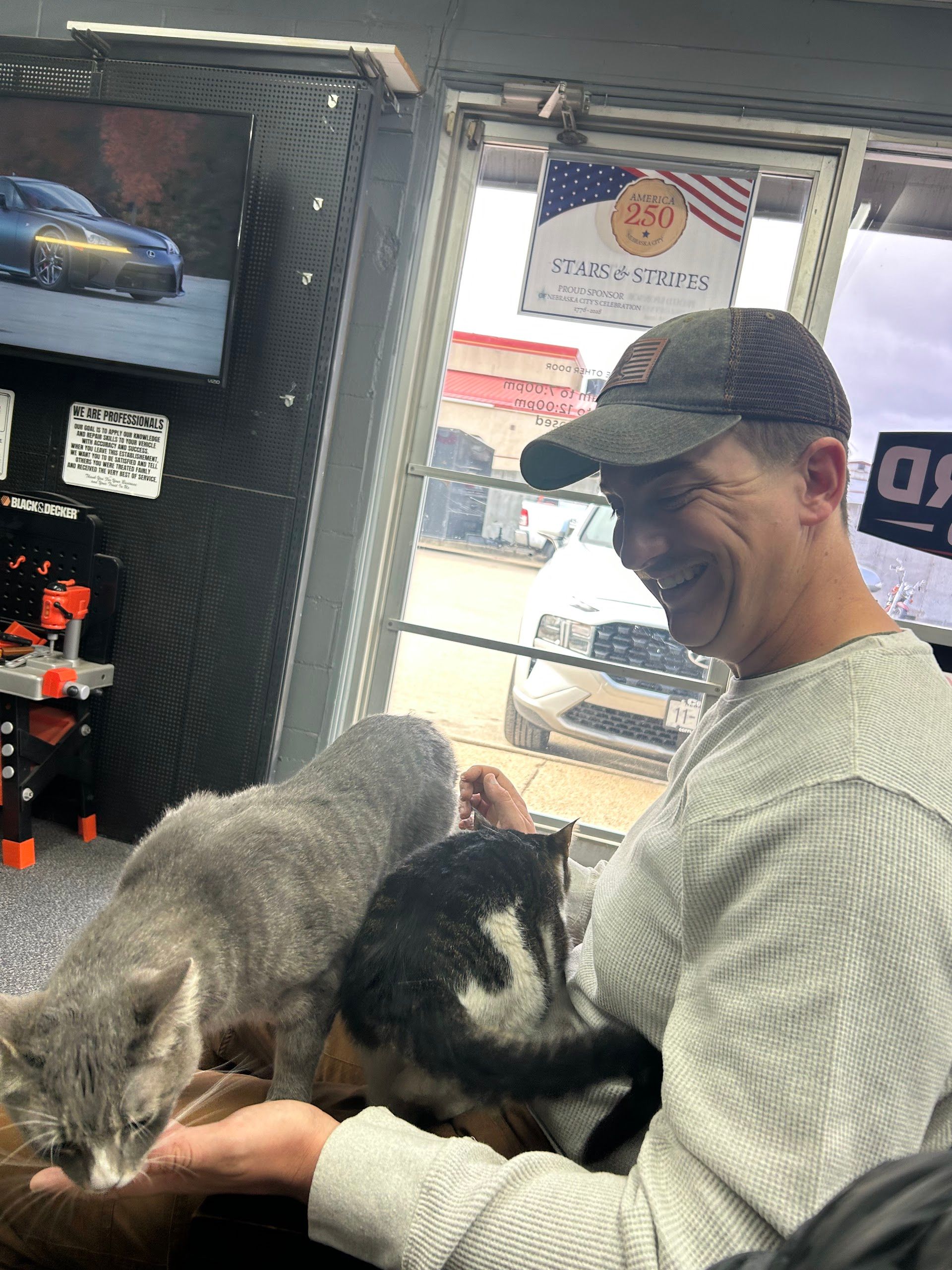 Smiling Customer Holding Shop Cat In Waiting Area | Lifeguard Tire and Auto