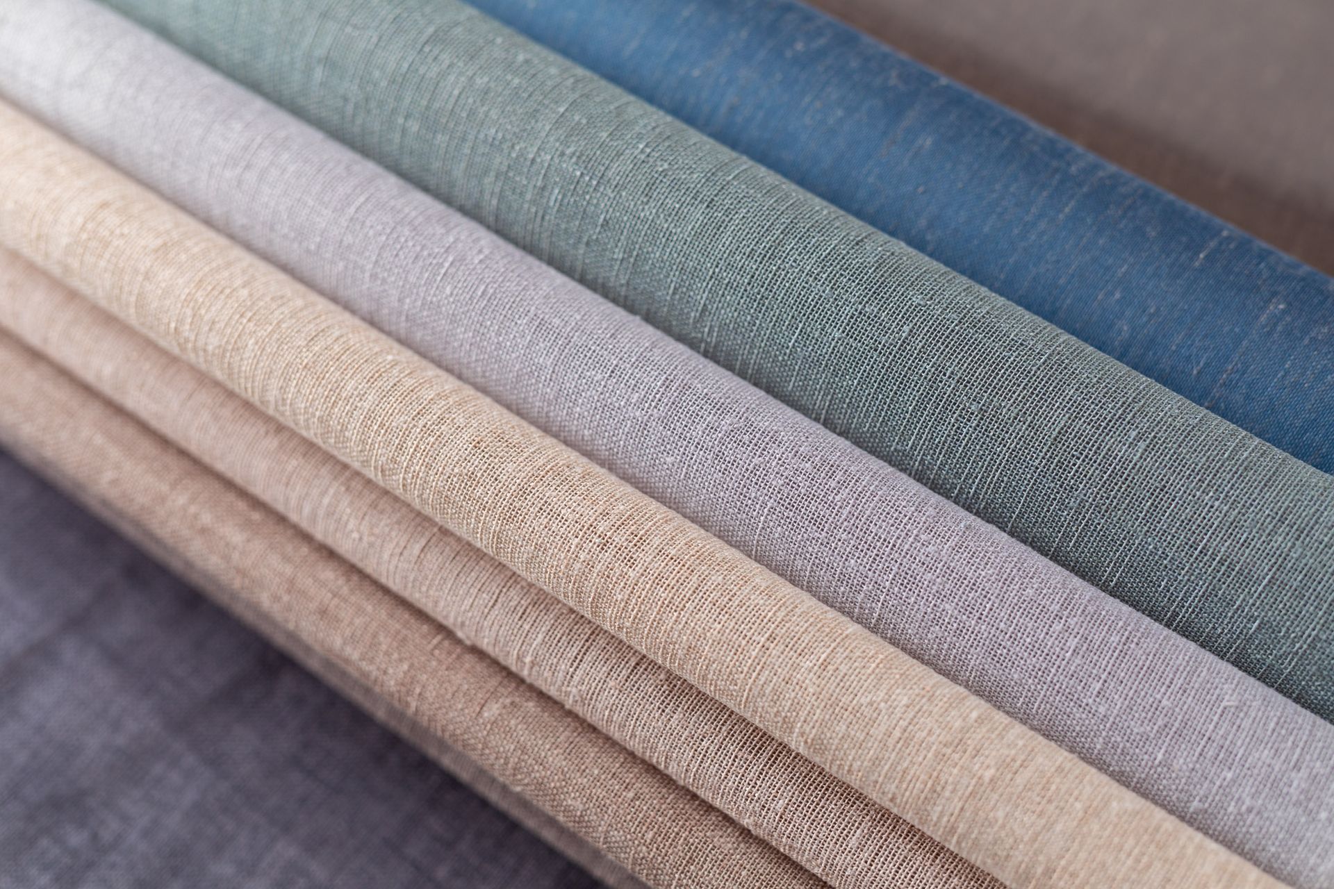 A close up of a stack of different colored fabrics.