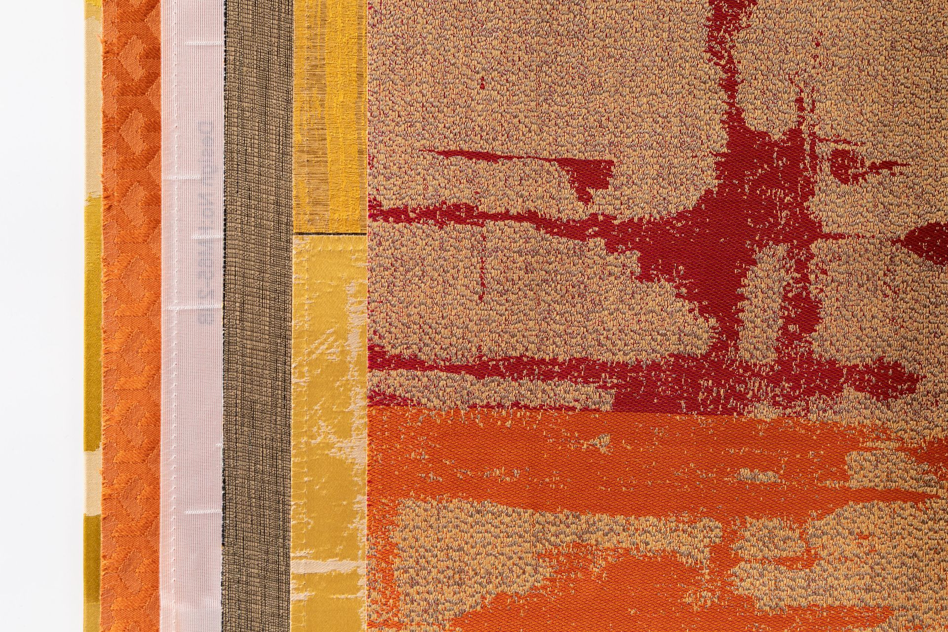A close up of a stack of colorful rugs on a white background.