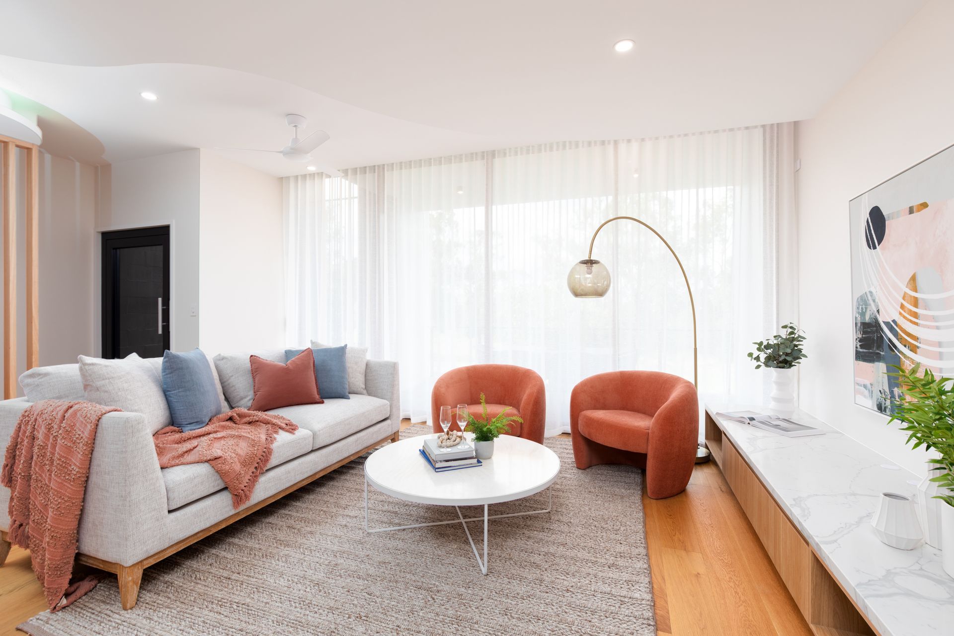 A living room with a couch , chairs , and a coffee table.