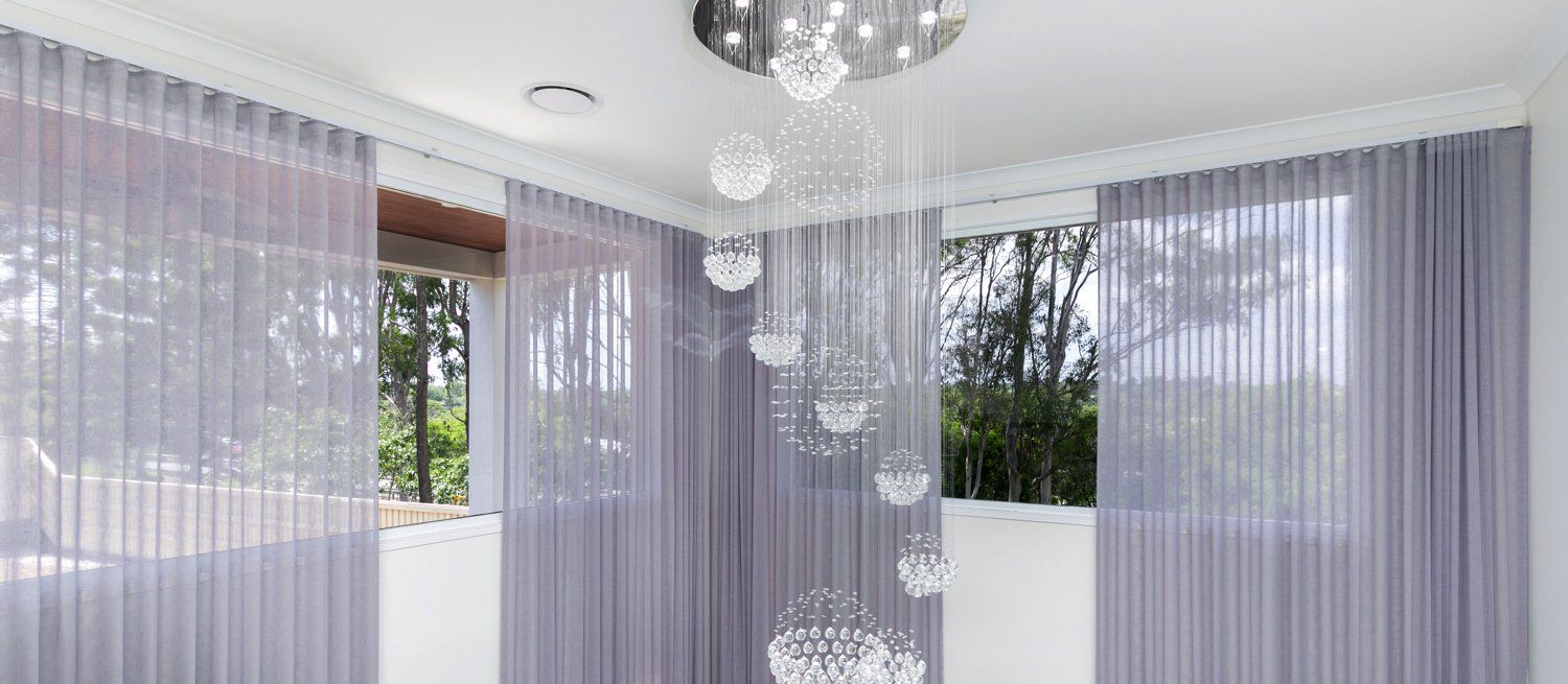 A room with purple curtains and a chandelier hanging from the ceiling.