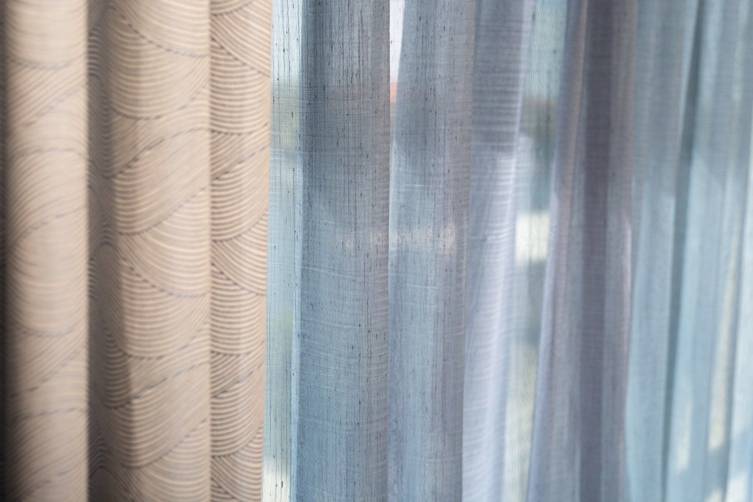 A close up of a row of curtains on a window.