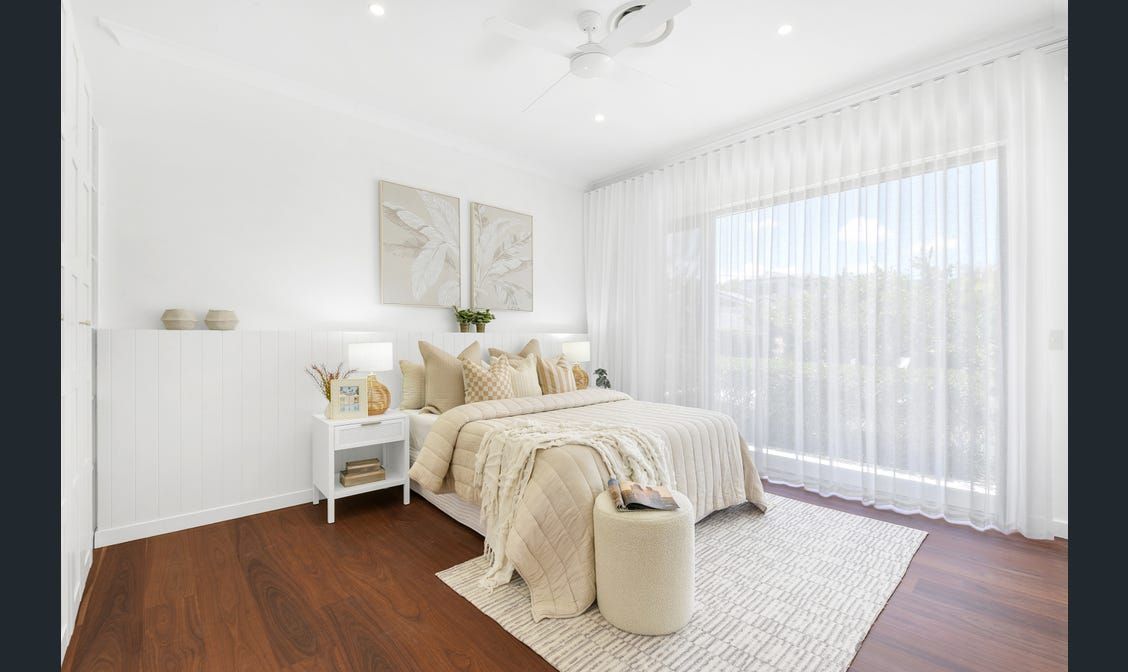 A bedroom with a bed , nightstand , rug and window.