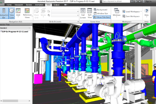 A computer screen shows a row of pipes and pumps in a factory.