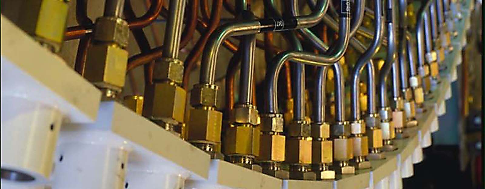 A row of brass pipes are lined up on a wall.