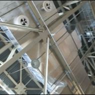 Looking up at the ceiling of a building with a lot of wires hanging from it.
