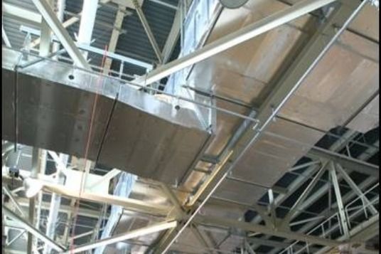A ceiling with a lot of pipes and wires