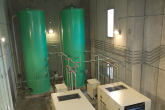 A room with green tanks and a machine in it.