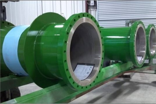 A bunch of green pipes are lined up on a table