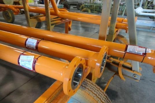 A bunch of orange pipes are stacked on top of each other
