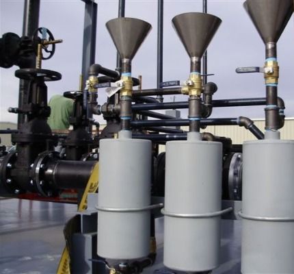 A row of pipes and valves with a yellow sign that says ' warning ' on it