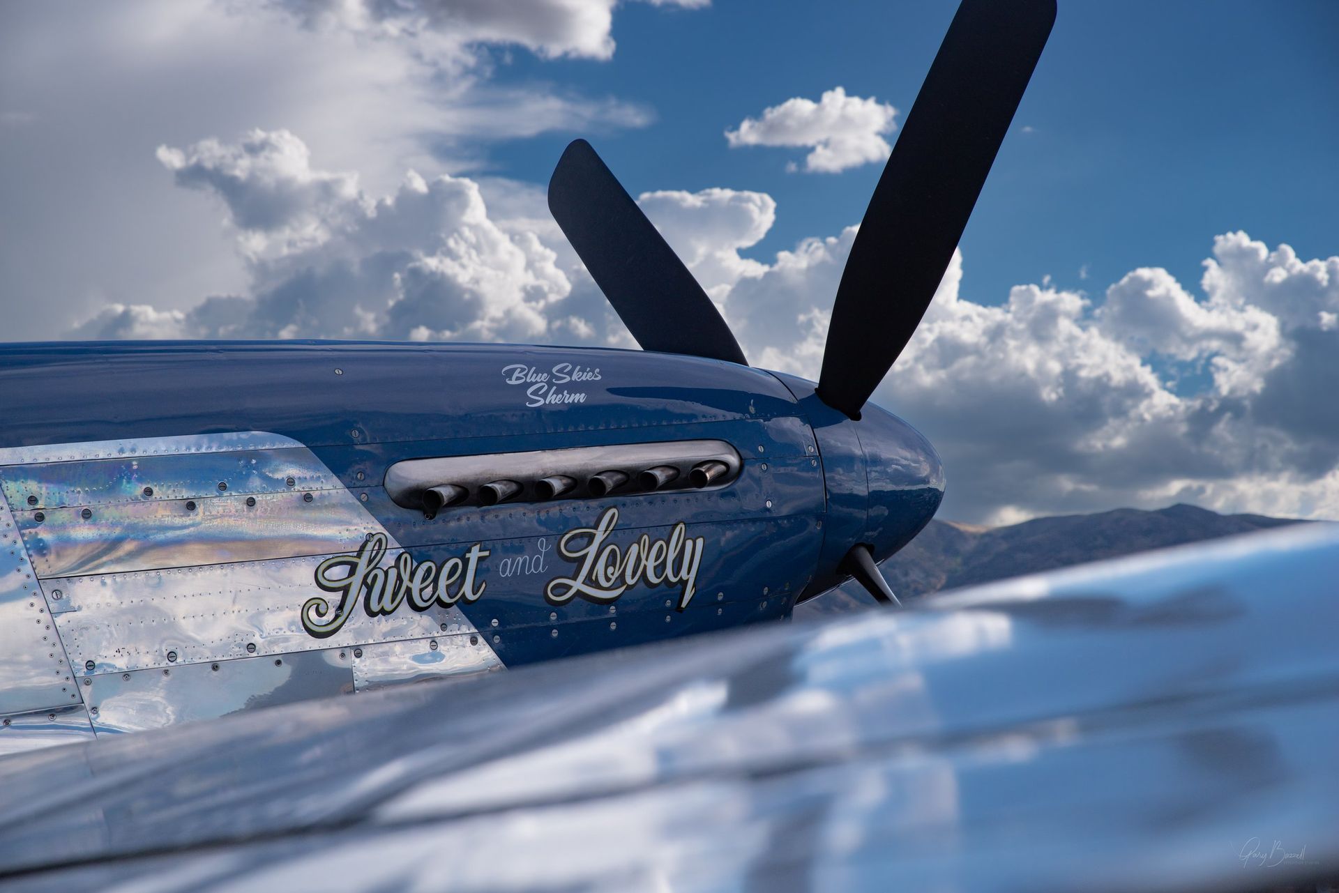 Blue aircraft named “Sweet Love” parked on a snowy runway under a cloudy sky.