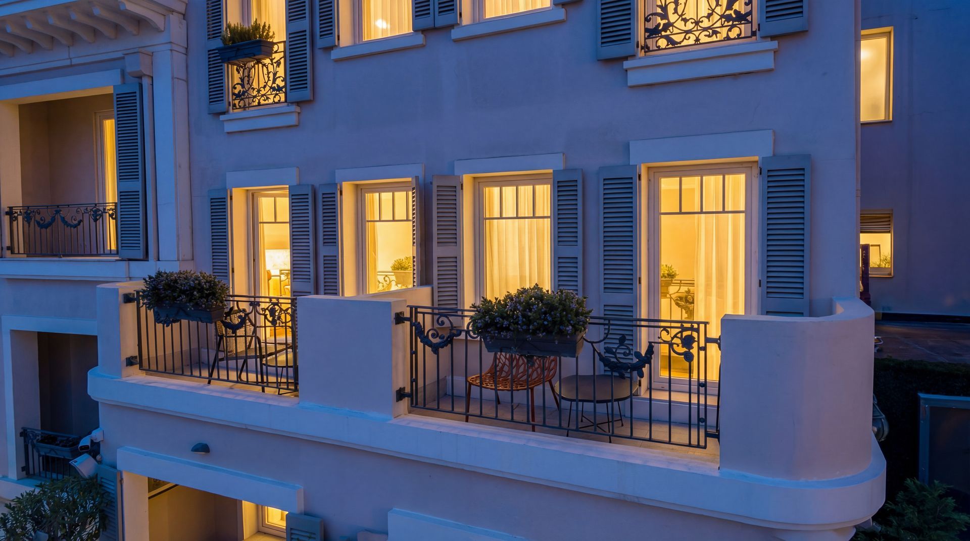 Blue-lit apartment balconies with warm glowing windows at dusk