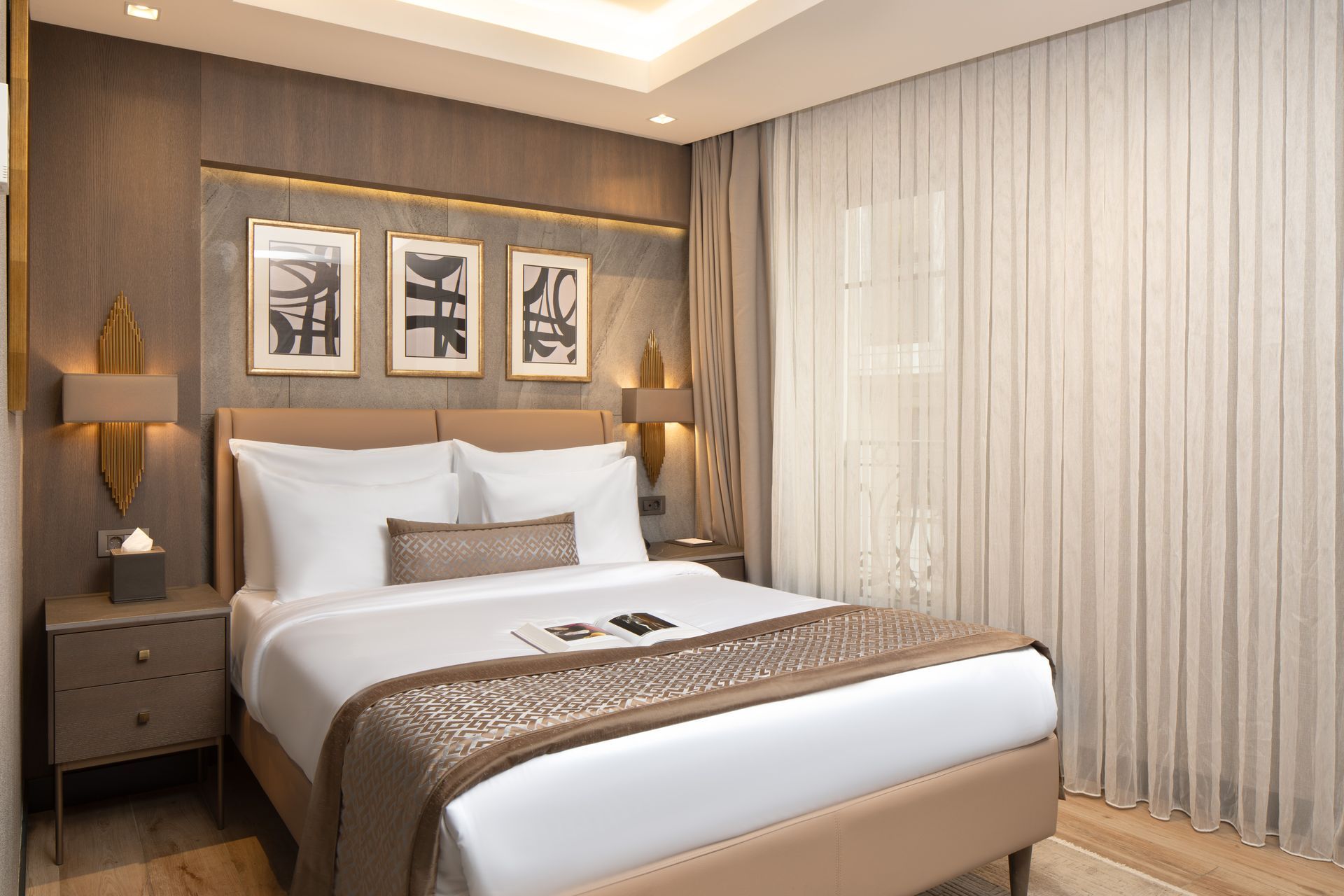 Modern bedroom with a white bed, wood accents, bedside lamps, and sheer curtains | Mula Hotel