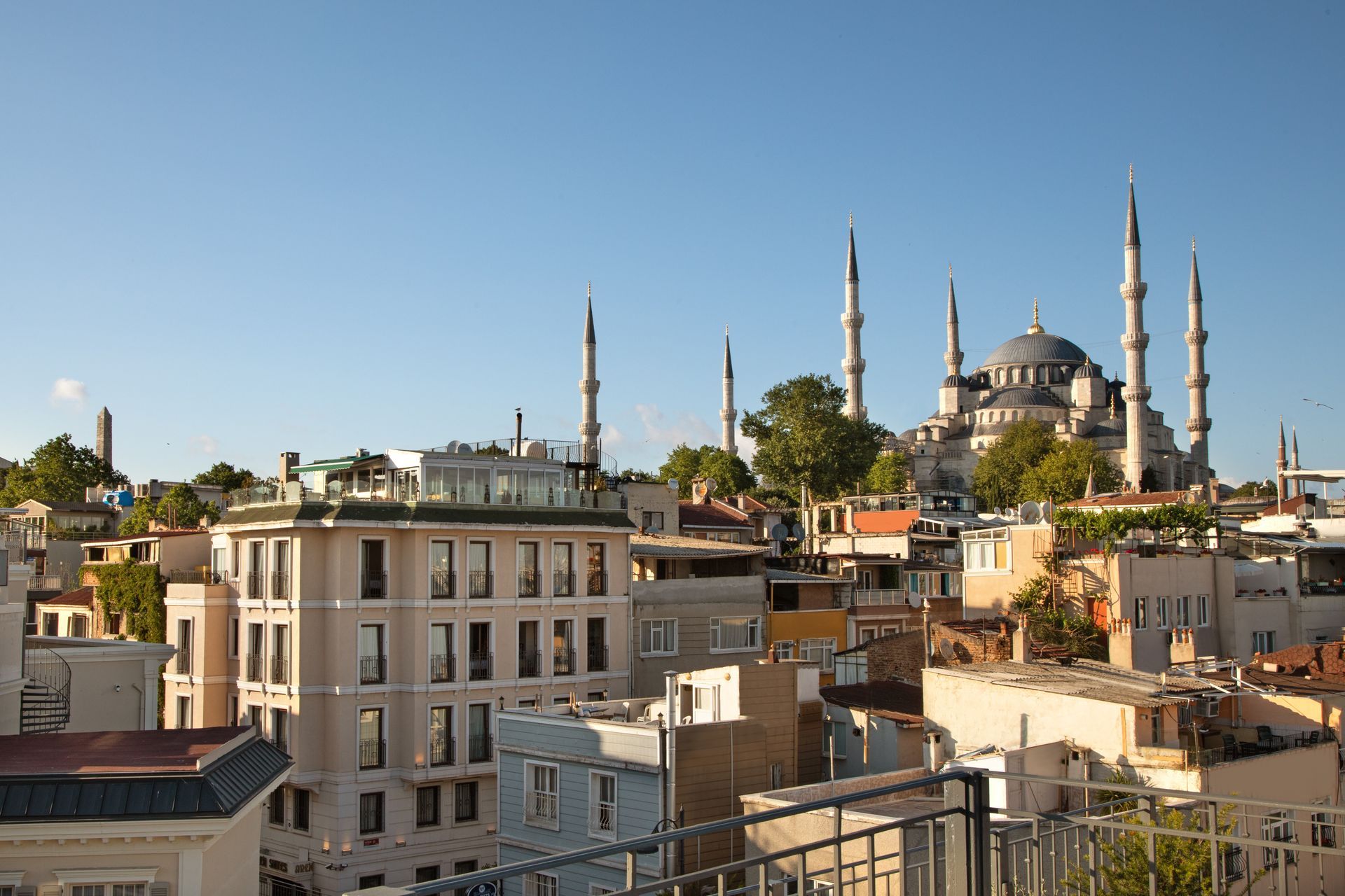City skyline with historic buildings and mosque minarets at sunset.