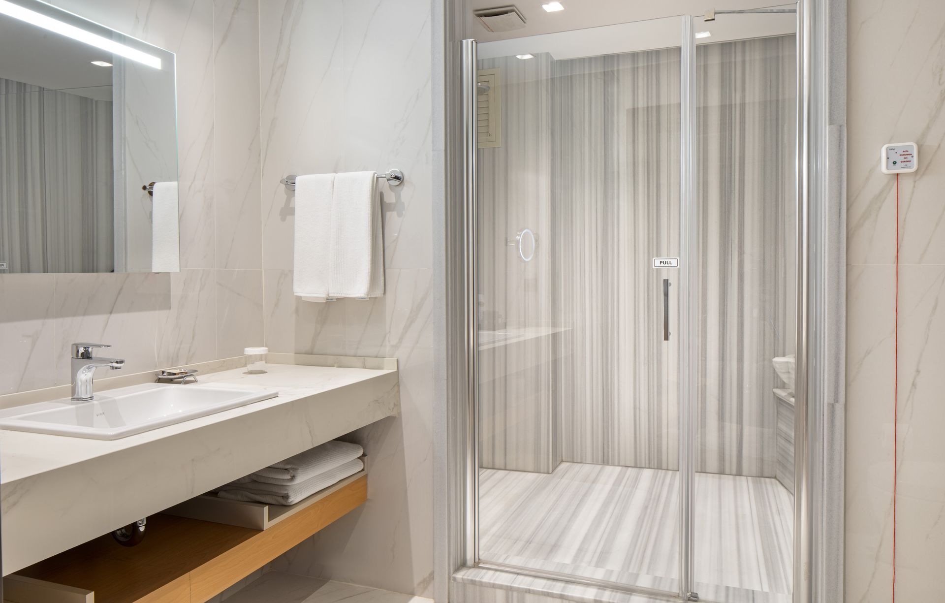Modern bathroom with a vanity, mirror, towel, and glass shower enclosure