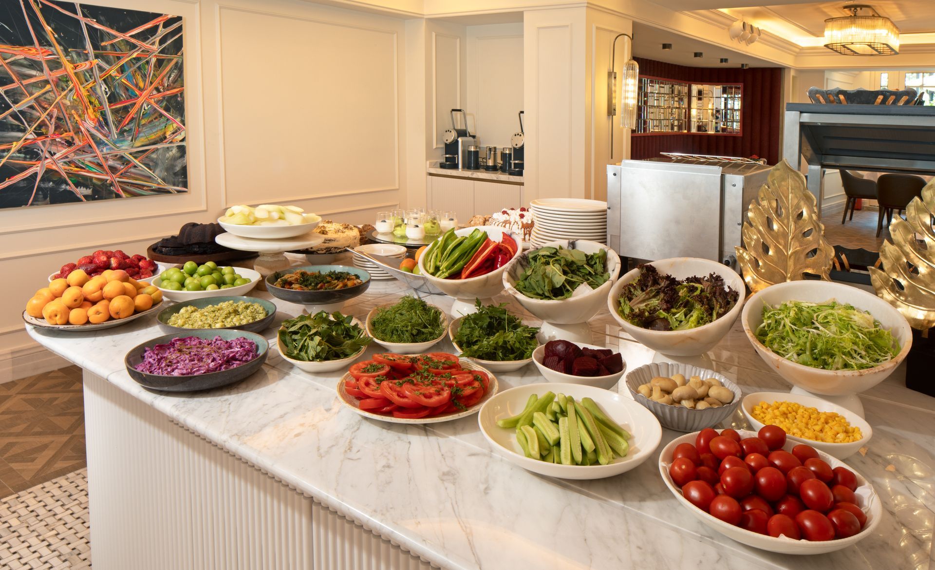 Buffet table with assorted salads, fruit, and appetizers in a bright banquet room