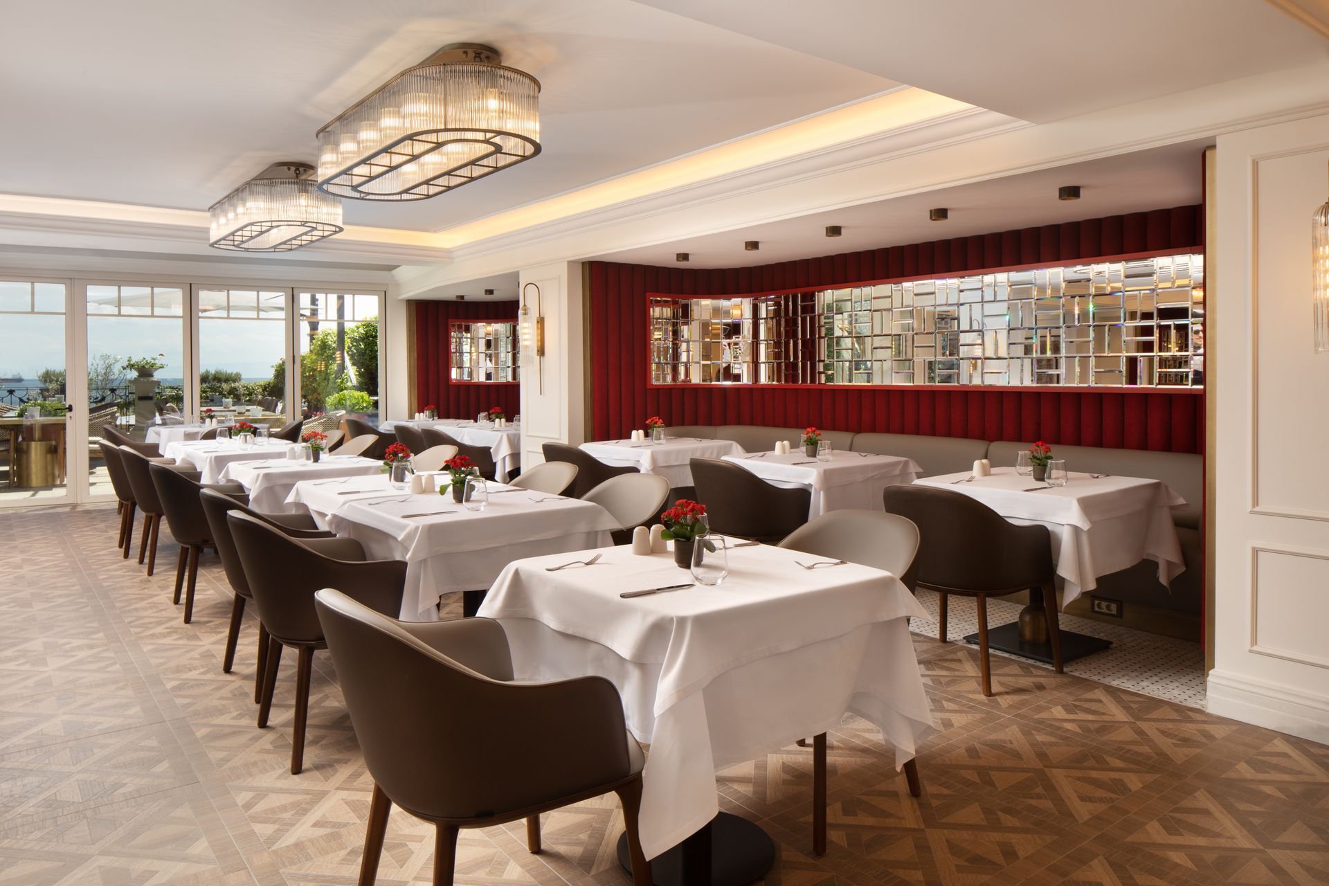 Elegant restaurant dining room with white tablecloths, dark chairs, and a long wine display