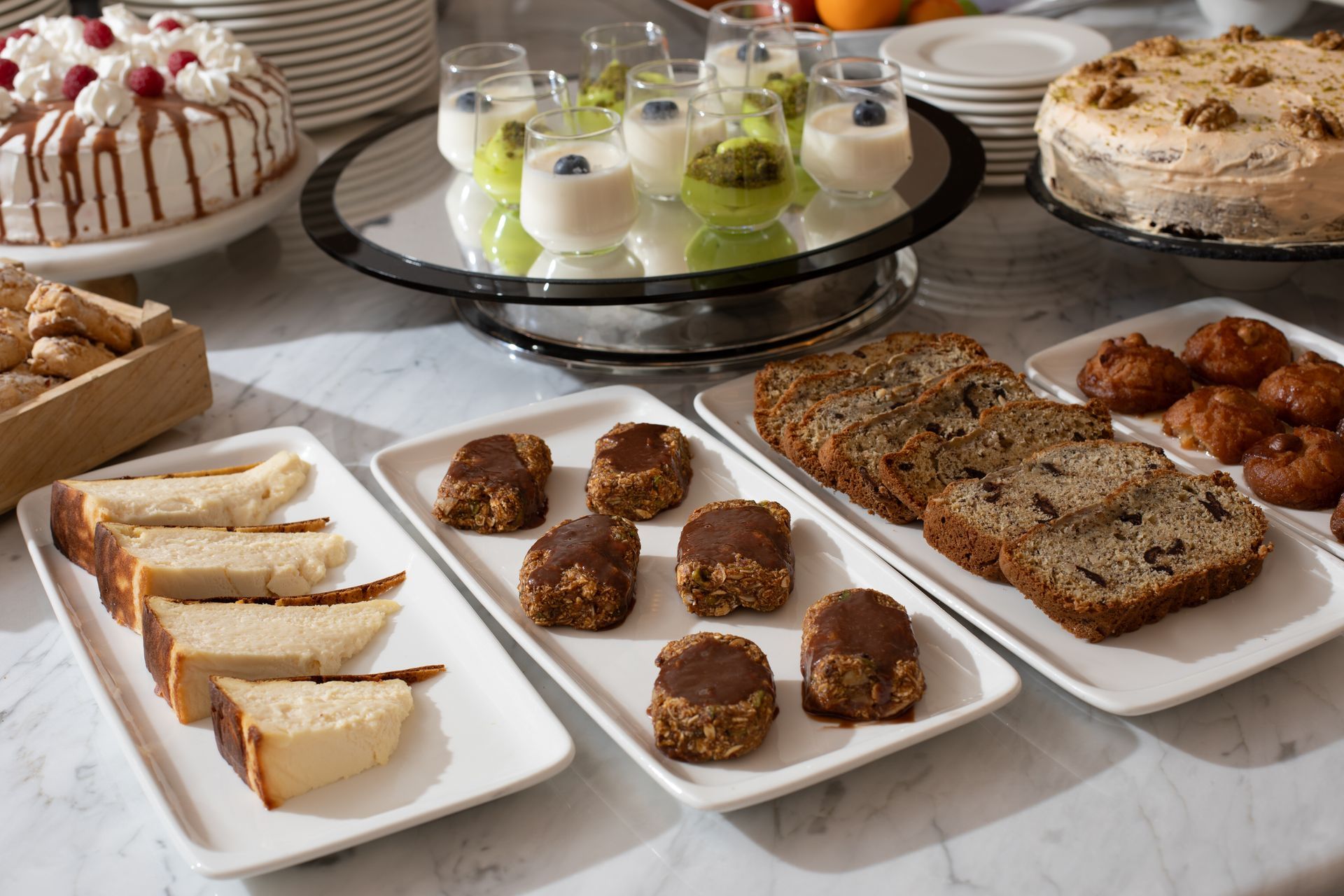Assorted pastries and desserts on white platters at a buffet table