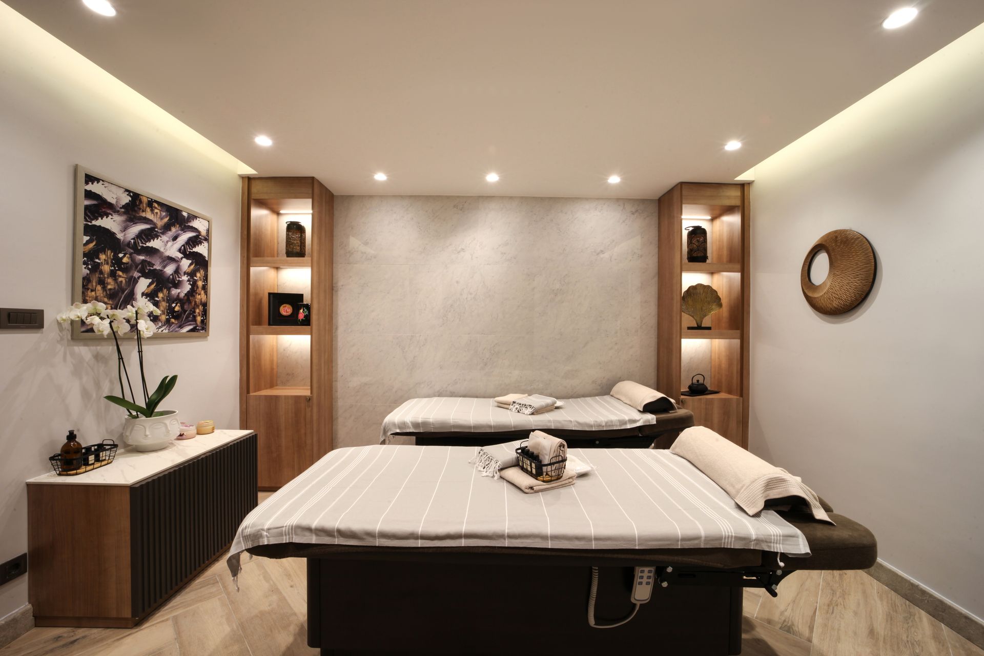 Bright modern bedroom with a large bed, wall-mounted TV, and city view through glass doors.