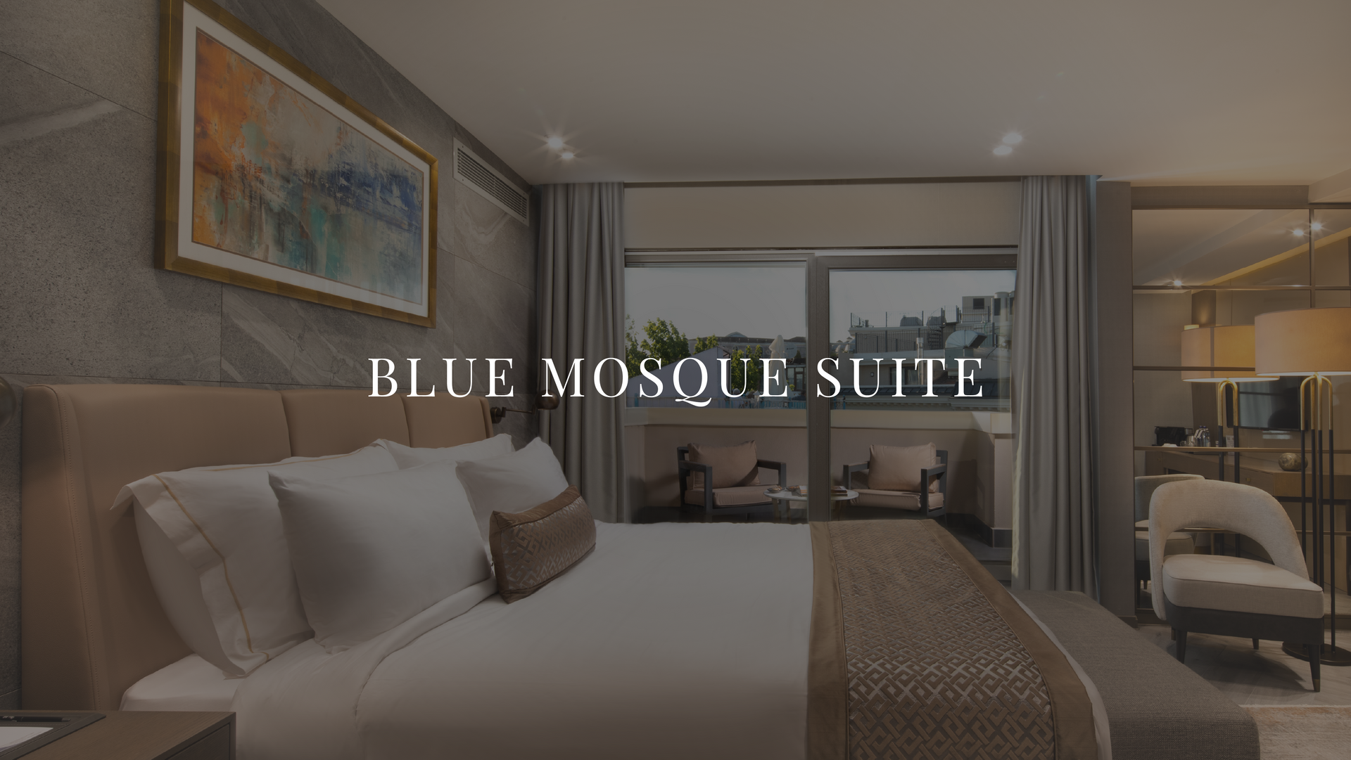 Luxury hotel bedroom labeled “Blue Mosaic Suite” with king bed, balcony view, and soft neutral decor
