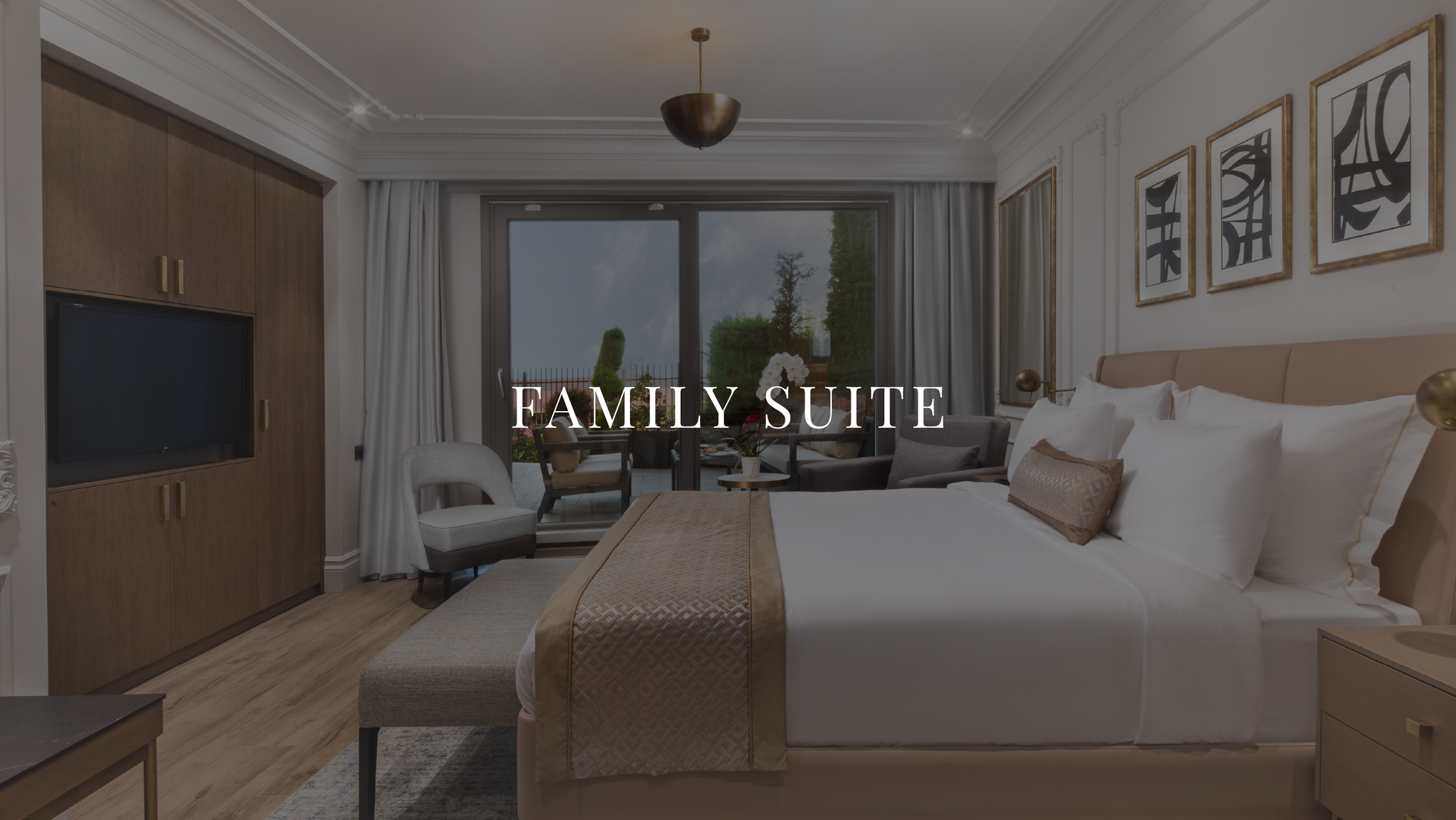 Hotel bedroom suite with king bed, TV, balcony, and “FAMILY SUITE” text overlay