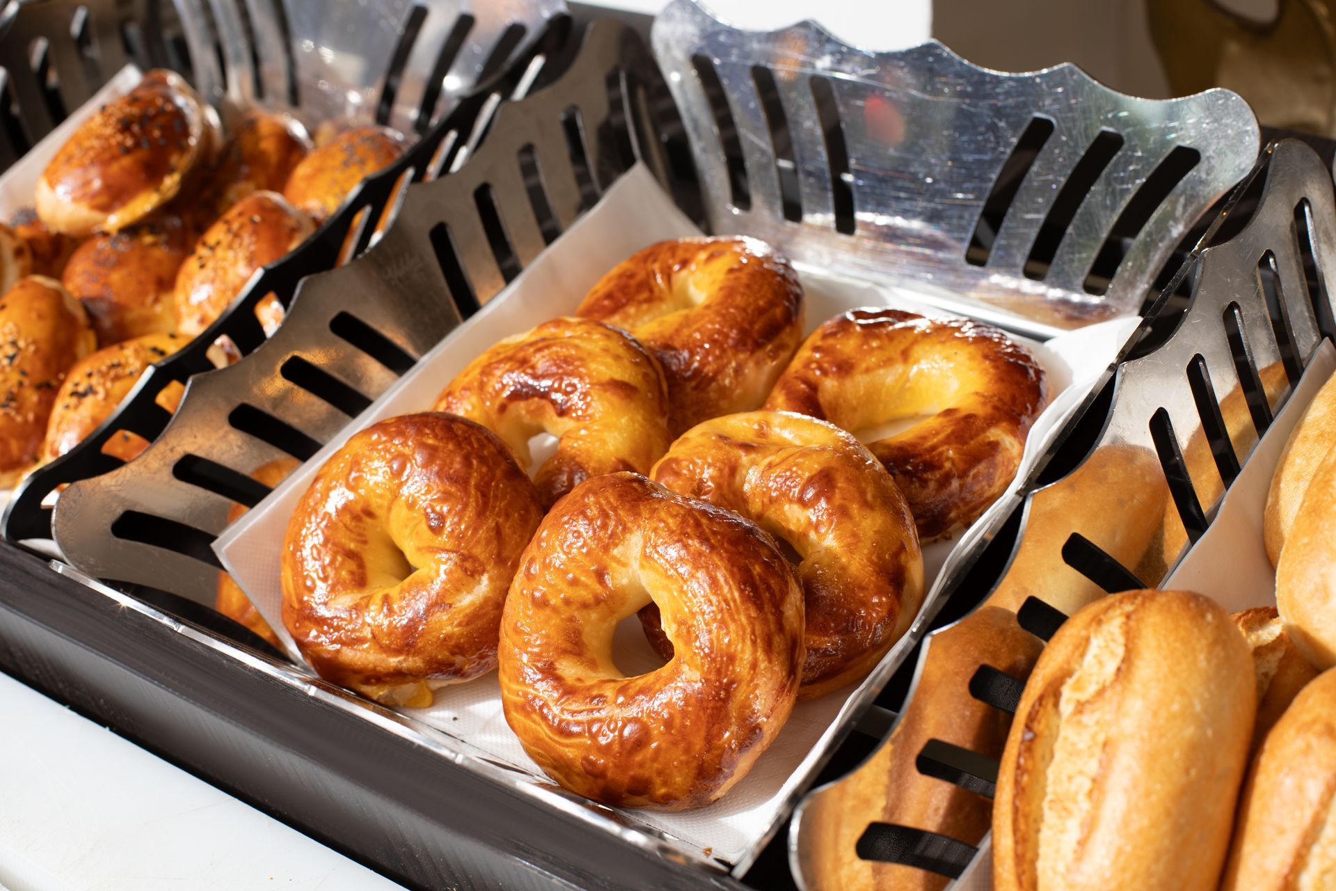 Mula Hotel | Baked goods in metal serving baskets, including bagels and rolls.