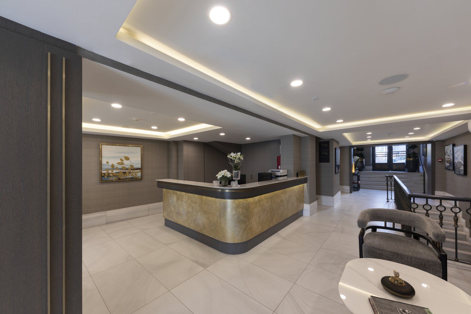 Resepsiyon masası ve sandalyenin bulunduğu bir otel lobisi.