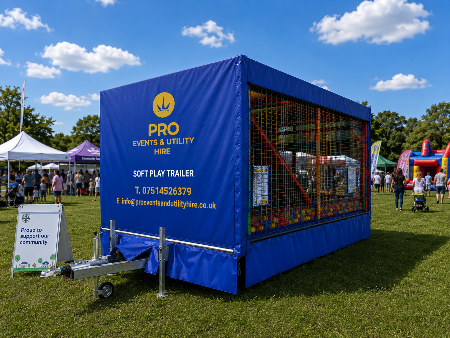 Blue promotional booth tent with netted sides at an outdoor fair on a grassy field