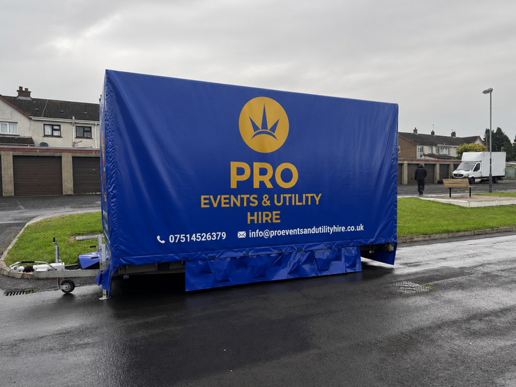 Blue trailer with PRO Events & Utility Hire branding parked on a wet street.