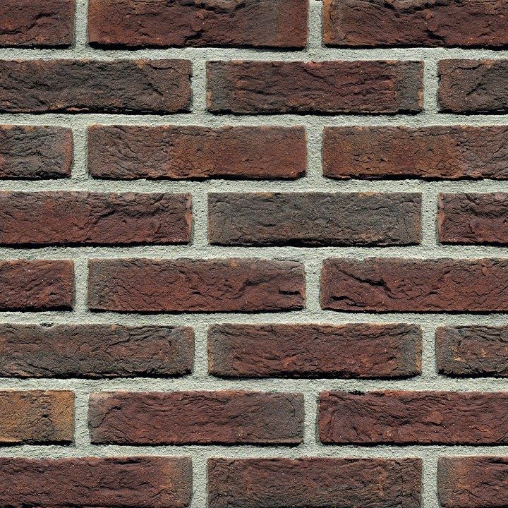 Close-up of a brick wall with red-brown bricks and gray mortar.