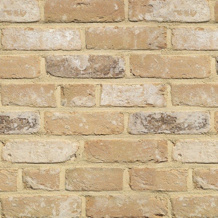 Tan brick wall with varying shades of tan and cream-colored bricks.