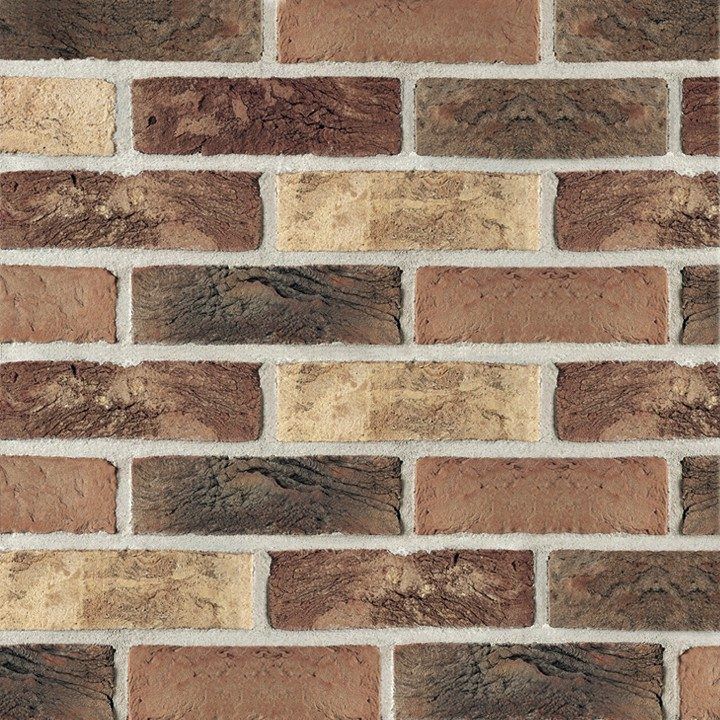 Brick wall with various shades of brown and beige mortar.