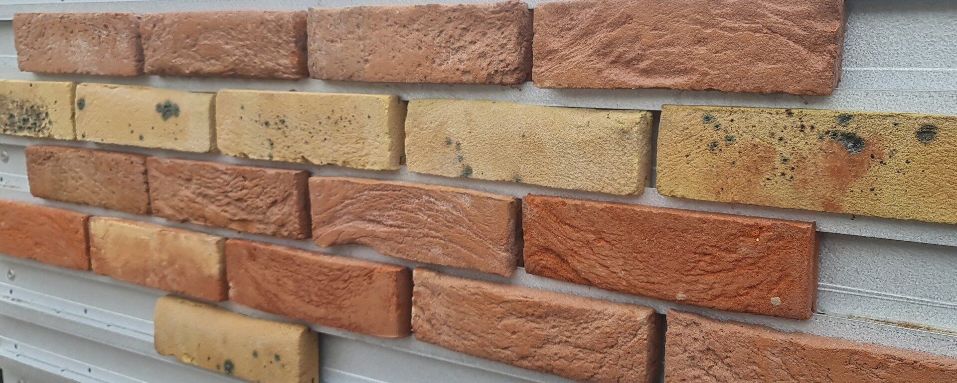 Close-up of a brick wall with red and yellow bricks in various shades.