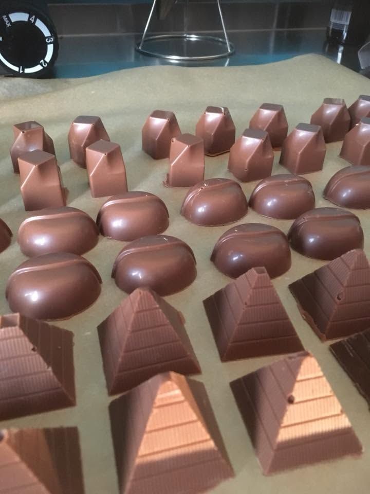 Whole filled chocolates arranged on a dark slate surface