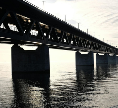 Bridge over water; dark silhouette against bright sky.