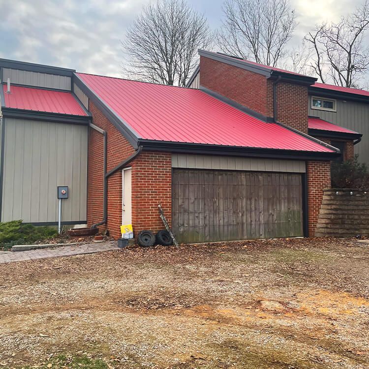 A brick house with a red roof and a garage door